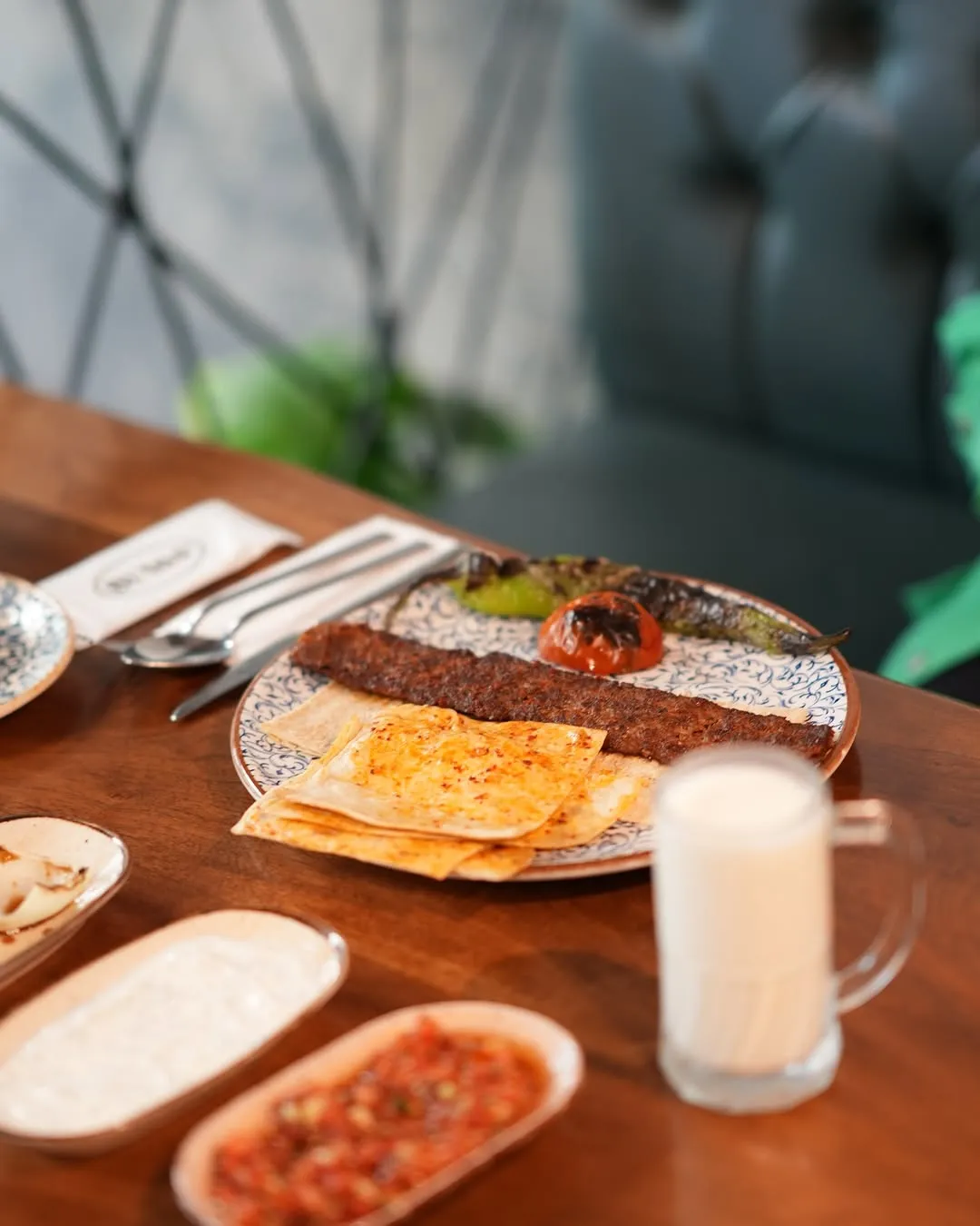 Tescilli Adana kebabı; közlenmiş biber, domates ve lavaş ile servis edilmiş tabak